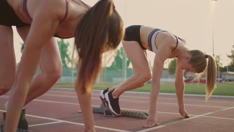 Das-Leichtathletikrennen-Der-Frauen-Ist-Alt.-Drei-Frauen-Im-Stadion-Bei-Sonnenuntergang-Laufen-Vom-Start-Weg.-Beginn-Des-Laufens